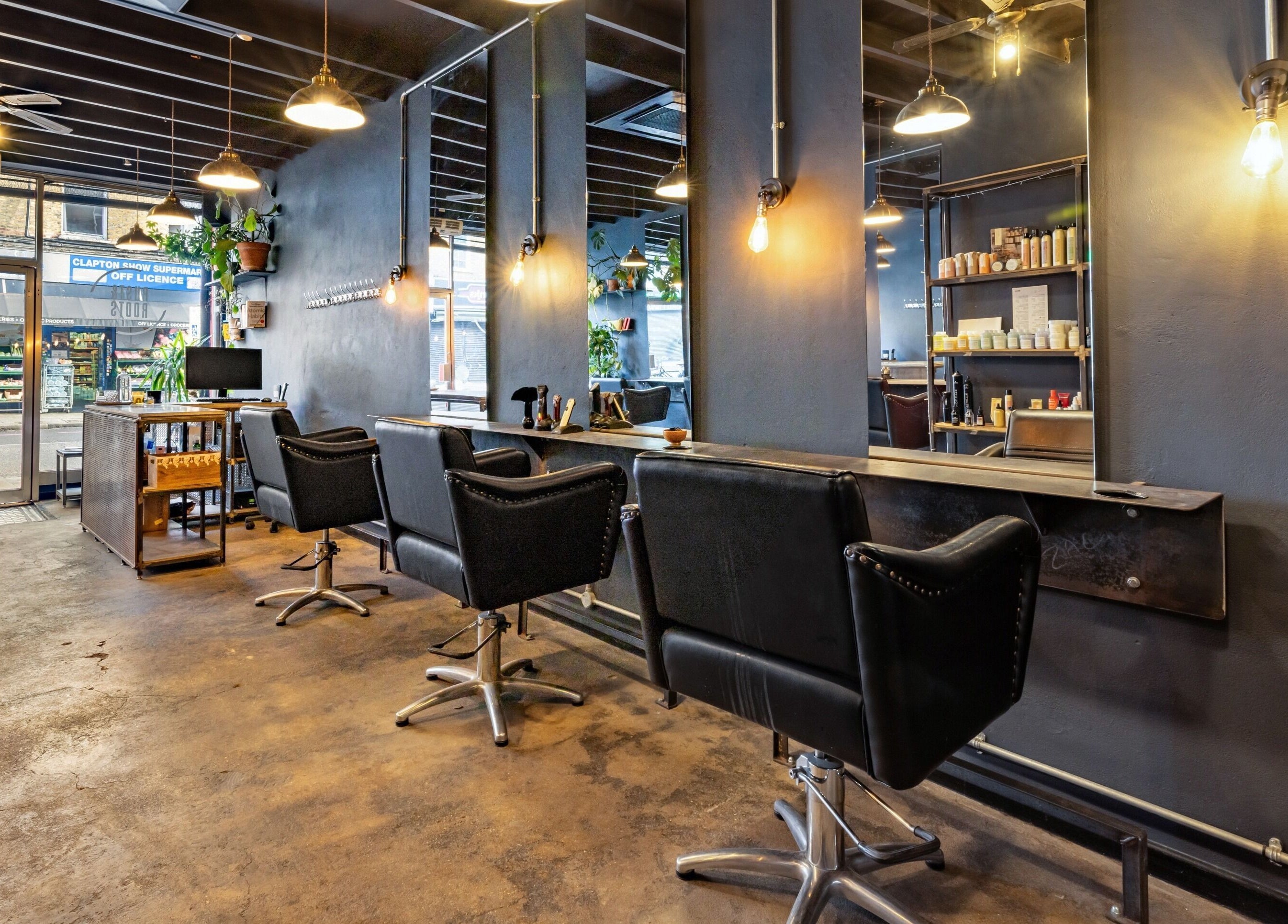 Modern salon interior at Rust & Roots, London, England, GB with stylish chairs and industrial decor.