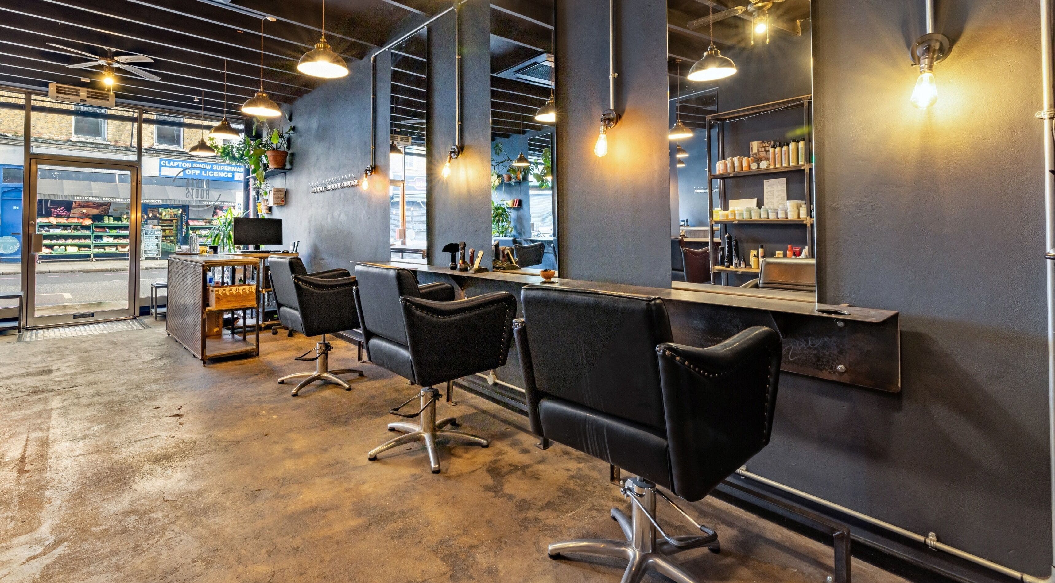 Modern salon interior at Rust & Roots, London, England, GB with stylish chairs and industrial decor.