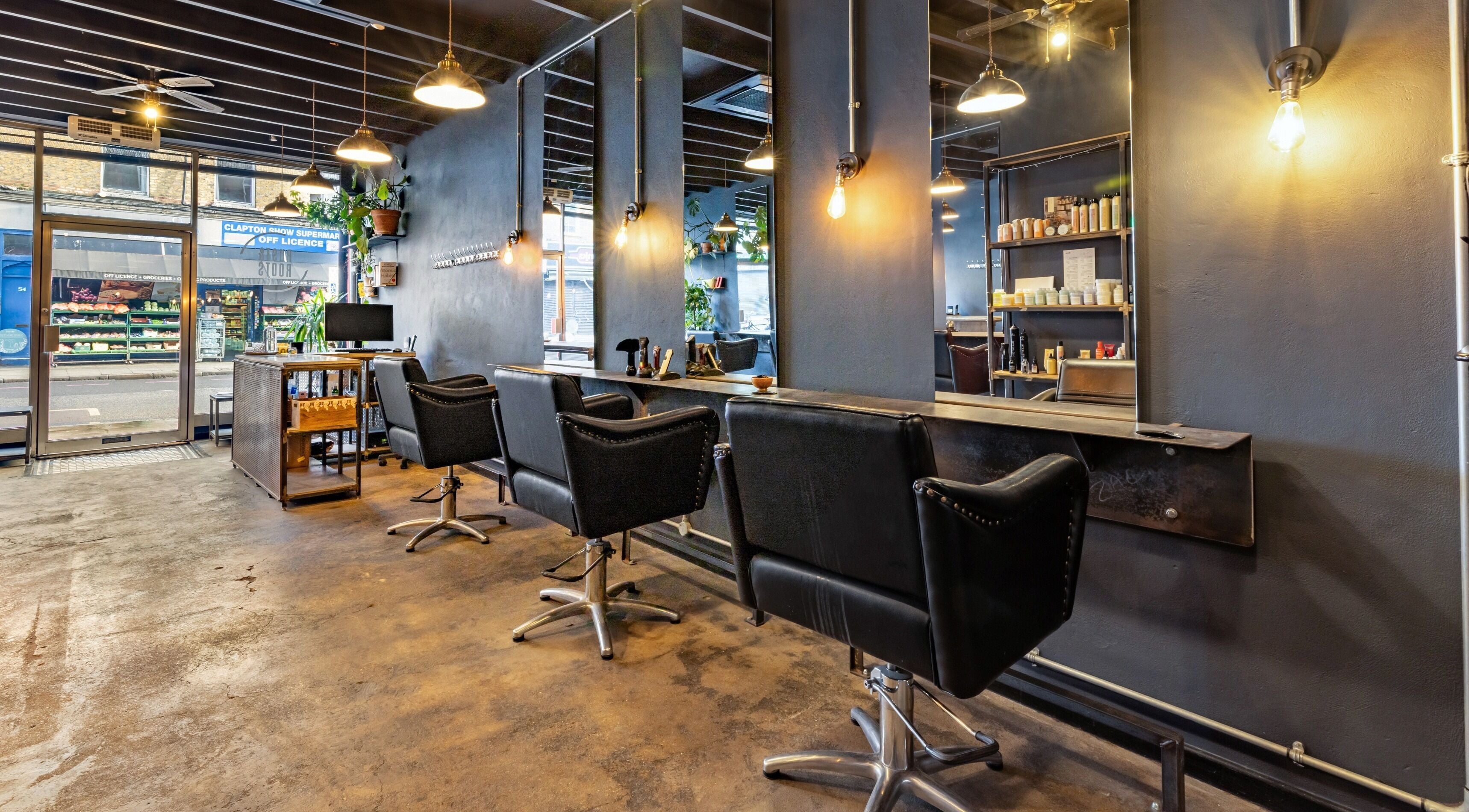 Modern salon interior at Rust & Roots, London, England, GB with stylish chairs and industrial decor.