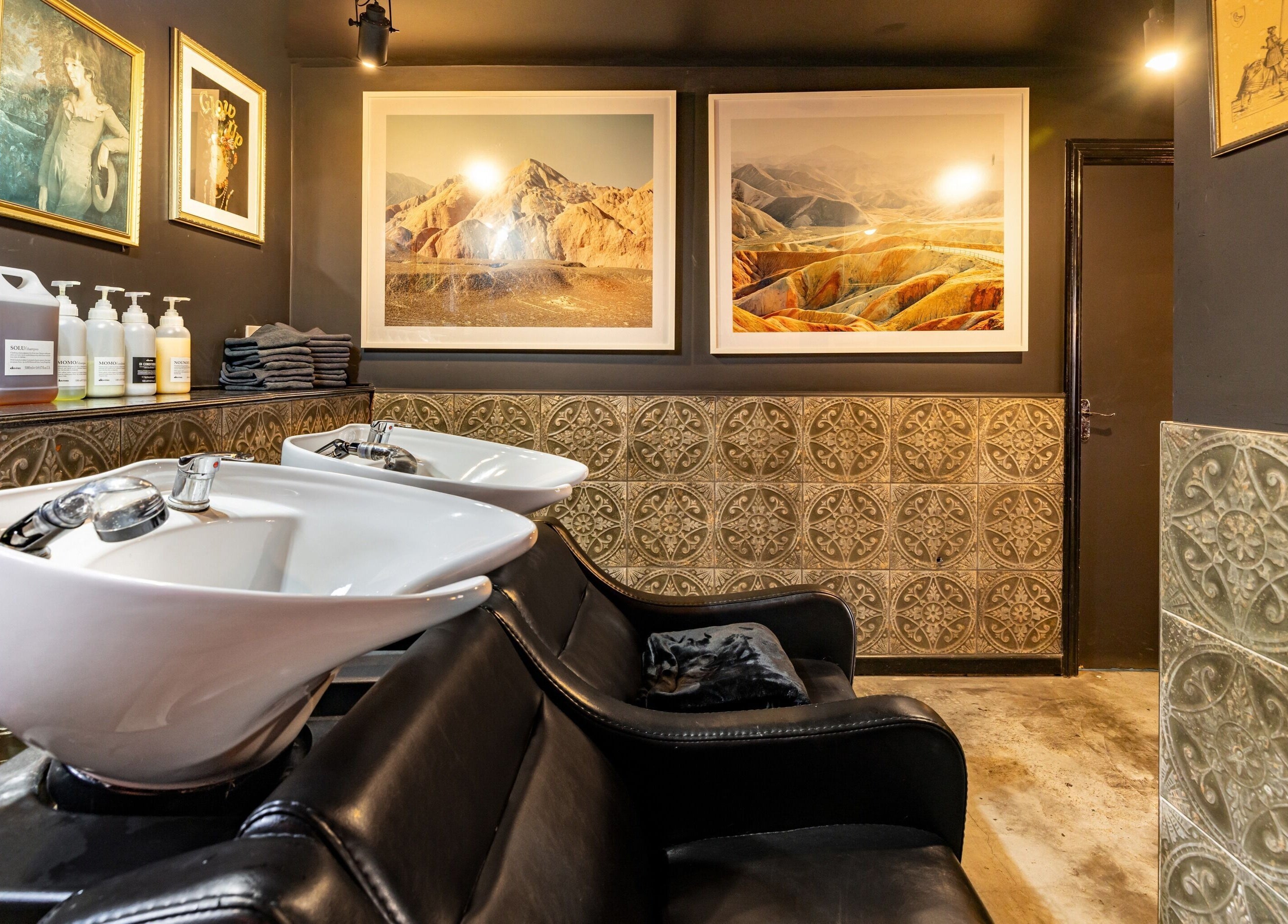 Rust & Roots wash station with art in London, England, GB. Stylish and inviting salon interior.