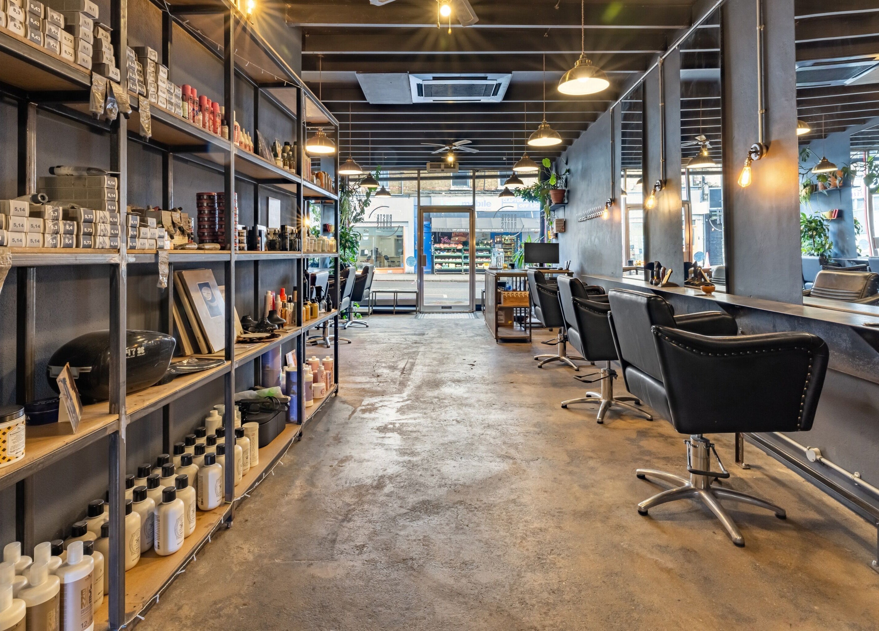 Rust & Roots salon interior with stylish decor, London, England, GB, showcasing beauty products and chairs.