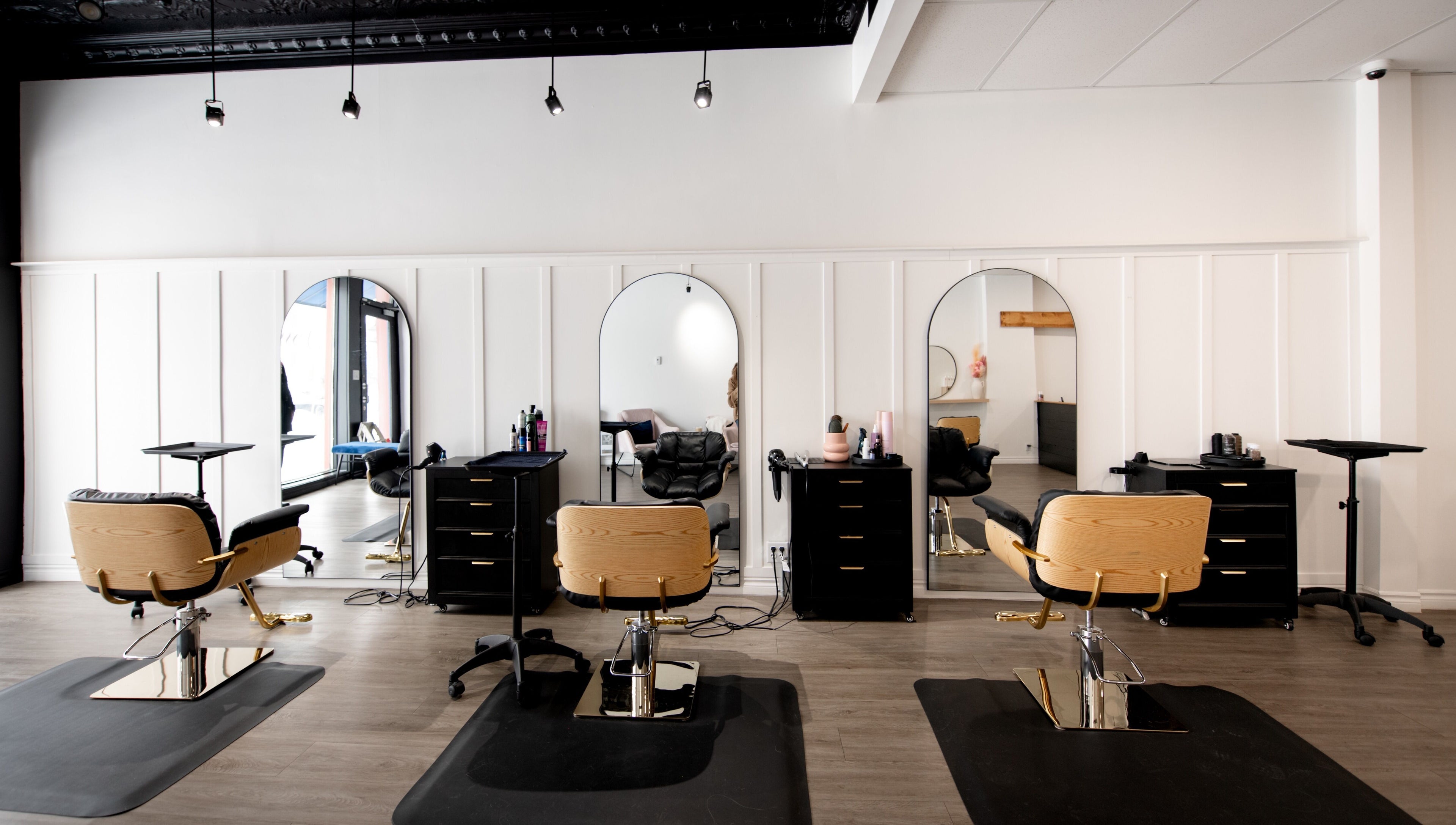 Intérieur élégant du salon de beauté Chez Madame C à Granby, Québec, CA avec chaises modernes et miroirs.