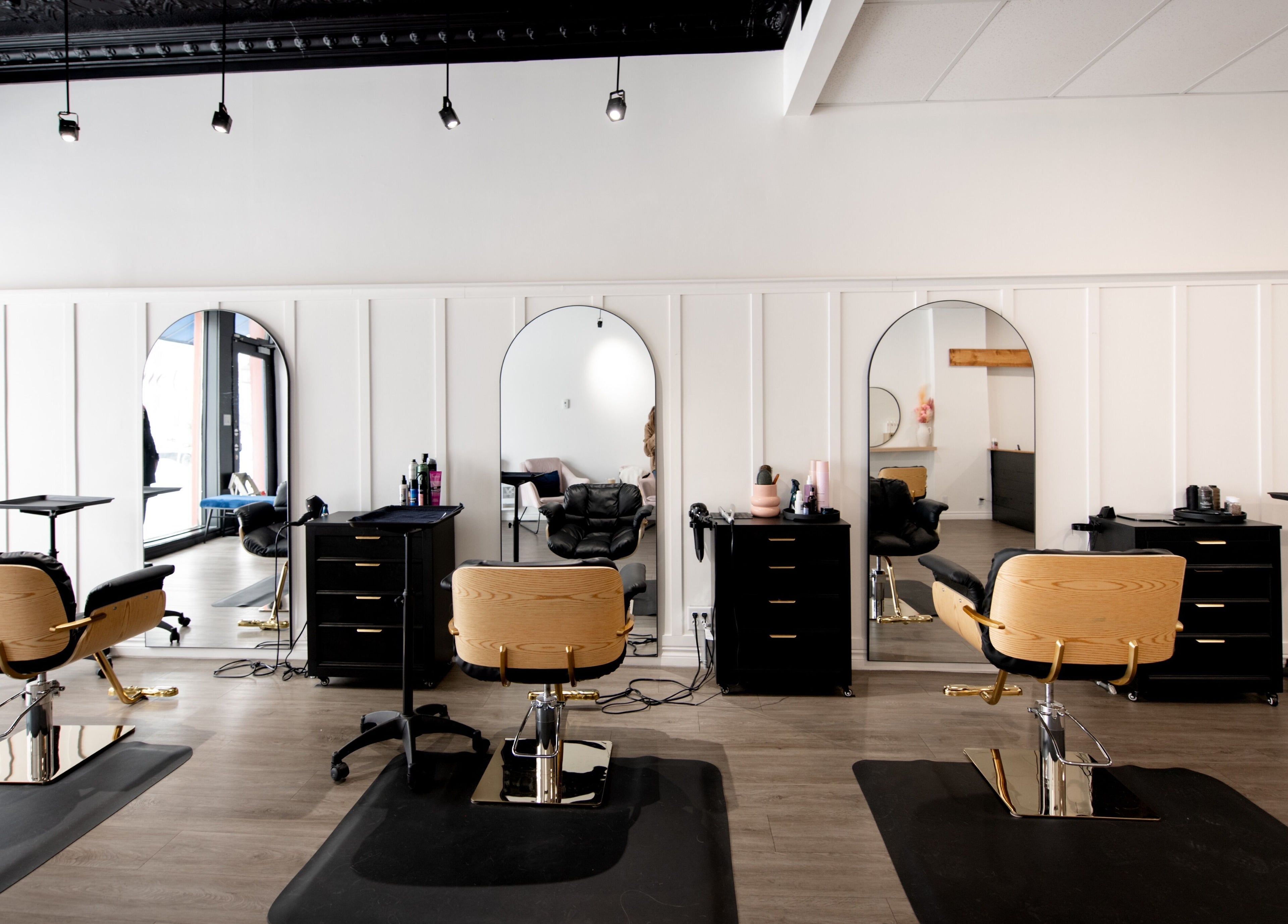 Intérieur élégant du salon de beauté Chez Madame C à Granby, Québec, CA avec chaises modernes et miroirs.