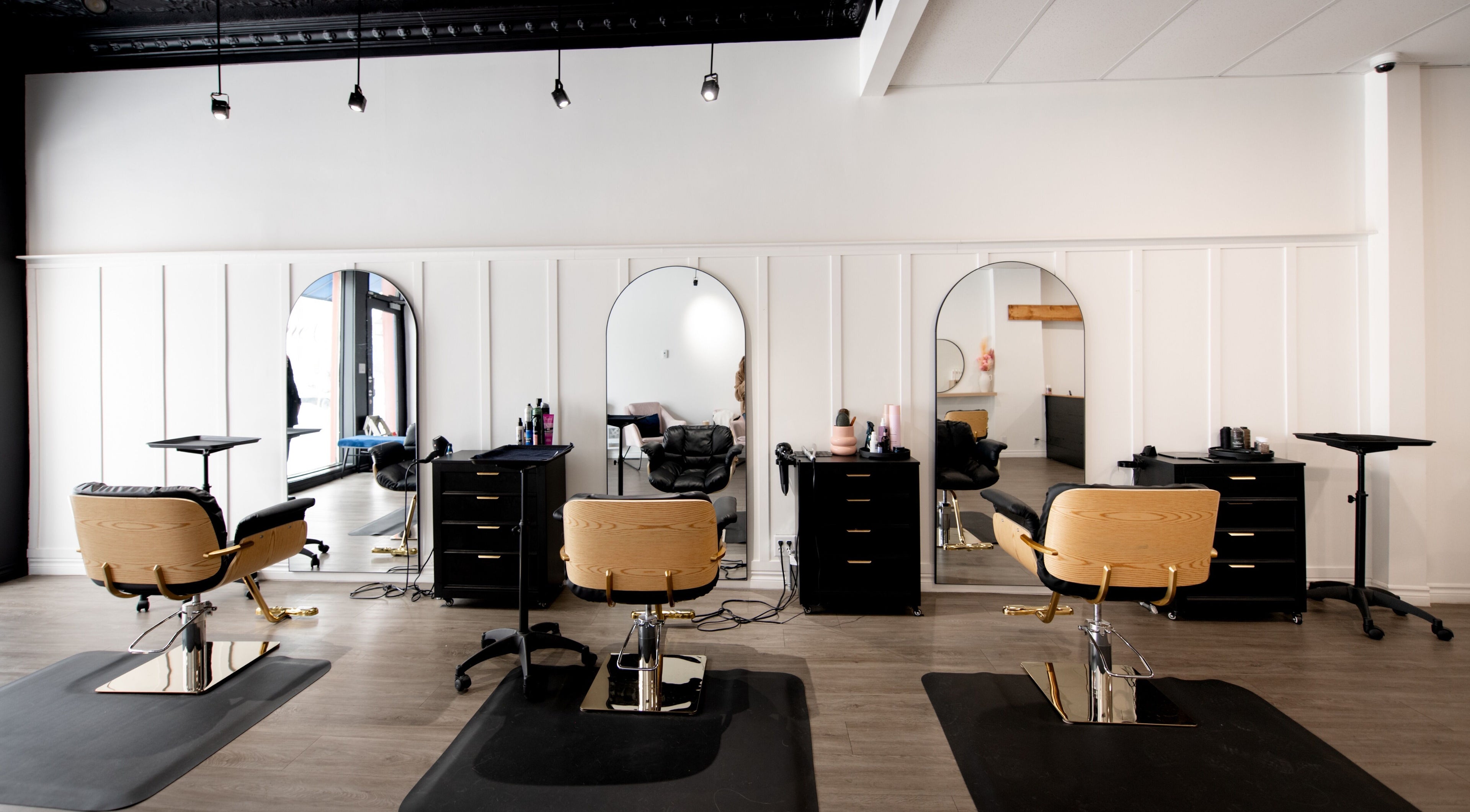Intérieur élégant du salon de beauté Chez Madame C à Granby, Québec, CA avec chaises modernes et miroirs.