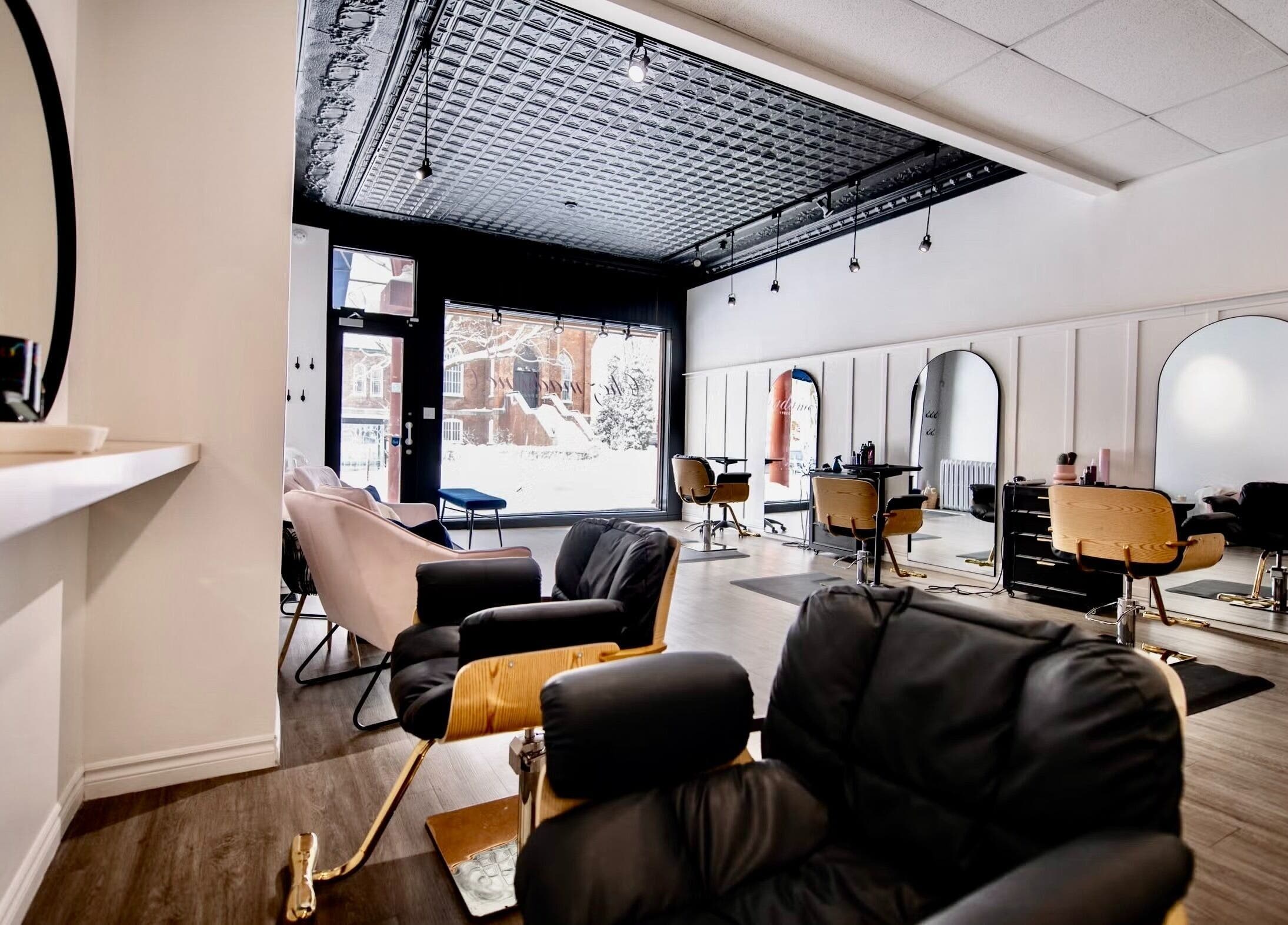 Intérieur moderne du salon Chez Madame C, Granby, Québec, CA. Fauteuils confortables et grands miroirs.