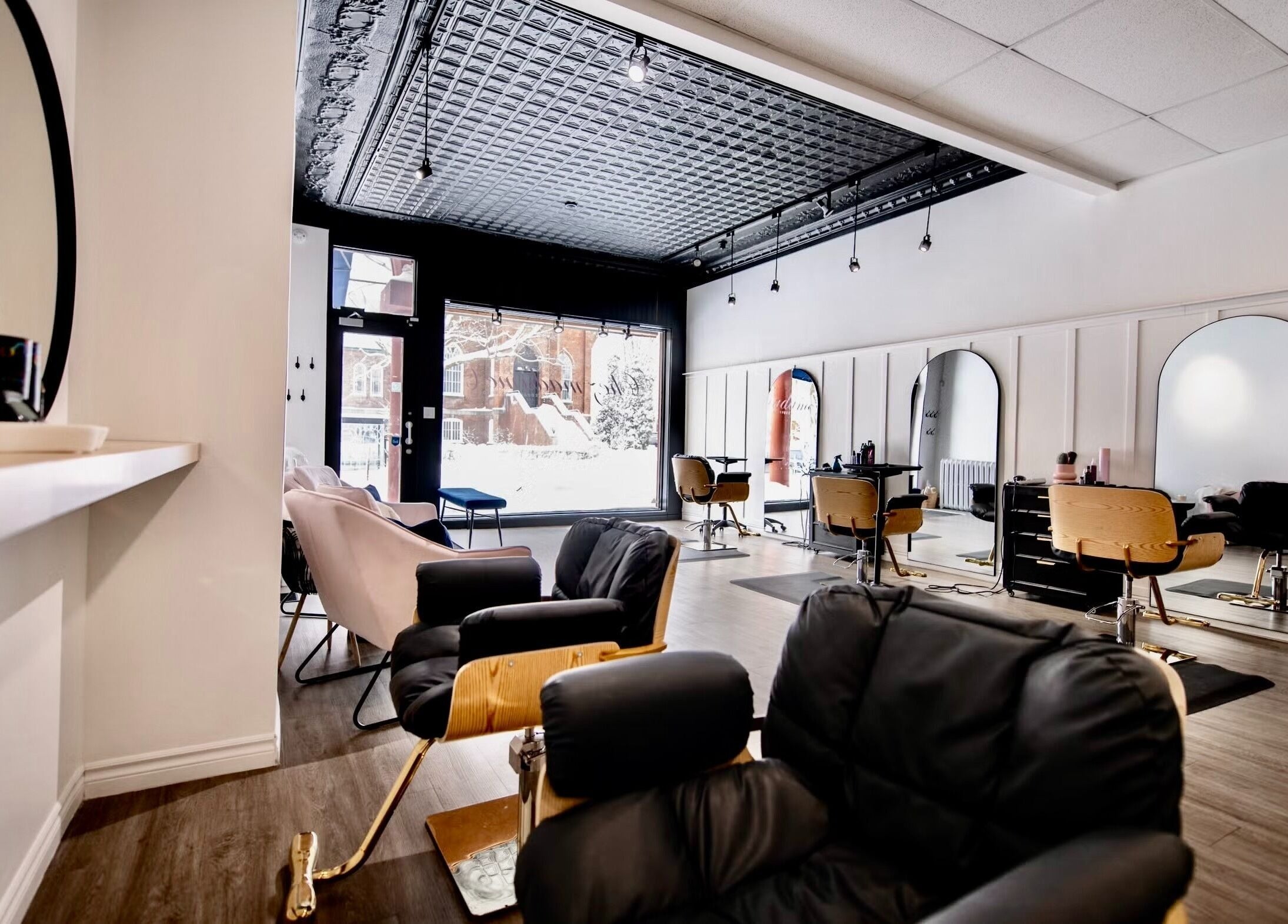 Intérieur moderne du salon Chez Madame C, Granby, Québec, CA. Fauteuils confortables et grands miroirs.
