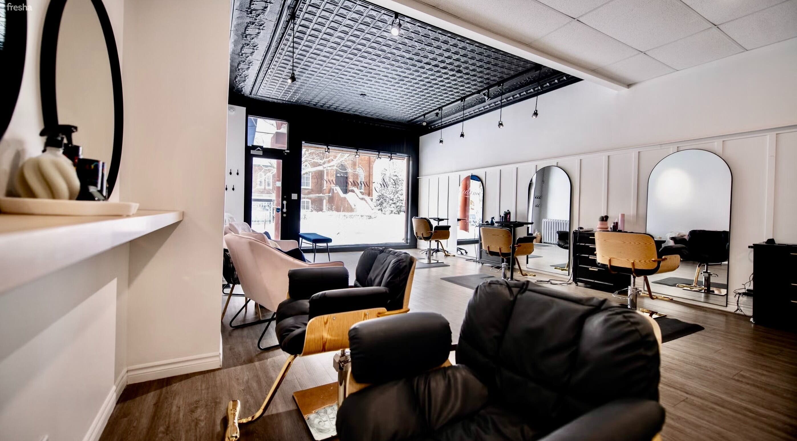 Intérieur moderne du salon Chez Madame C, Granby, Québec, CA. Fauteuils confortables et grands miroirs.