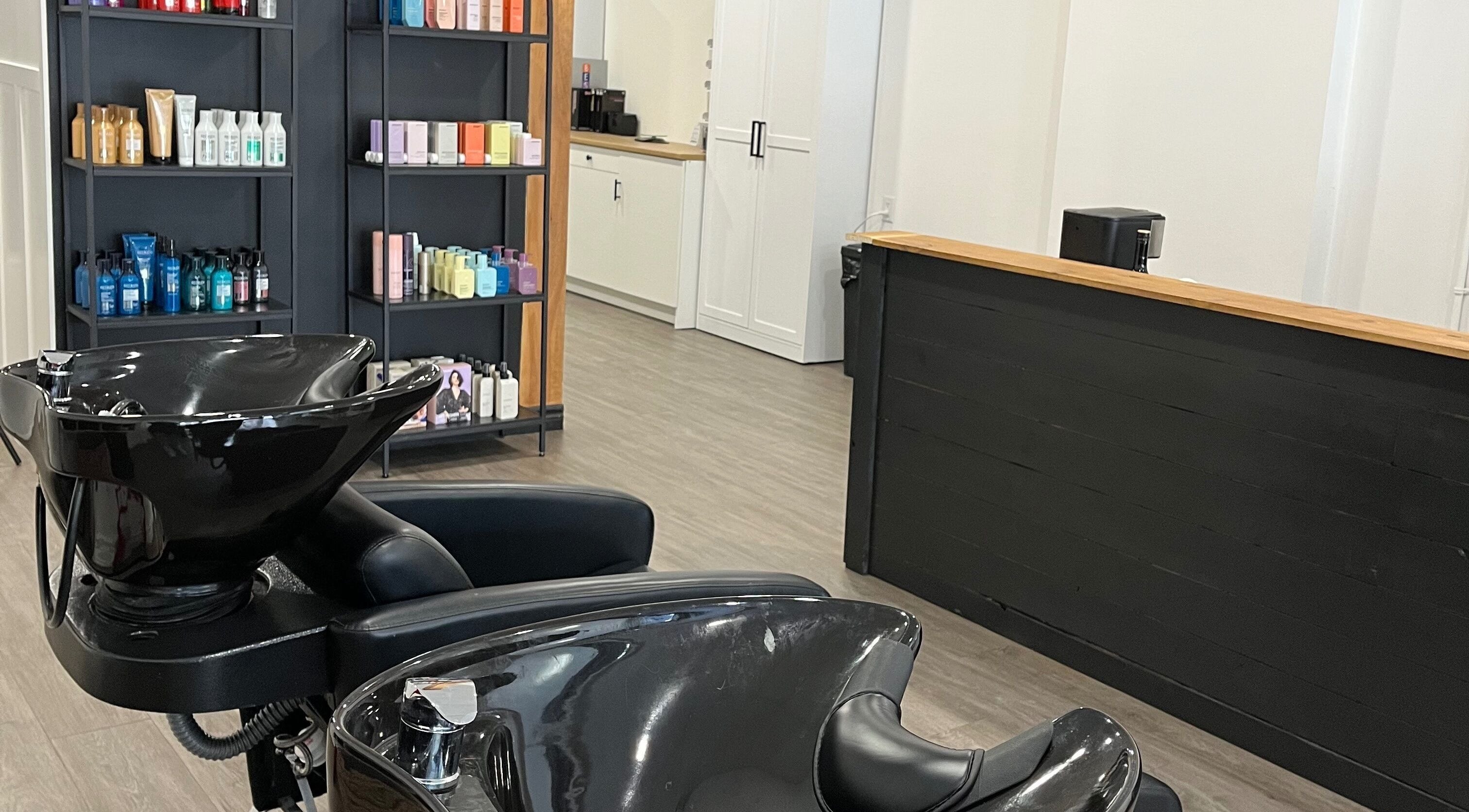 L'espace lavage moderne du salon Chez Madame C à Granby, Québec, CA, avec produits capillaires en arrière-plan.