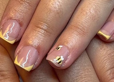 Stylish bee-themed nails with yellow French tips at Beauty By Poppy Marina, Bury, England, GB.