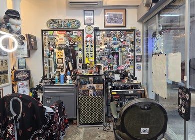 Interior of Big Bad Wolf Barbershop in Singapore, SG, showcasing vibrant sticker-covered walls and barber tools.