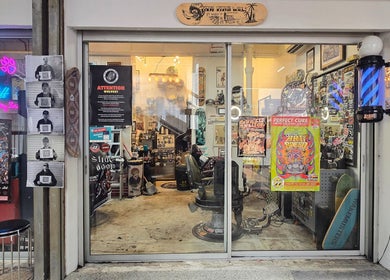 Entrance of Big Bad Wolf Barbershop in Singapore, SG showcasing retro decor and vibrant posters.