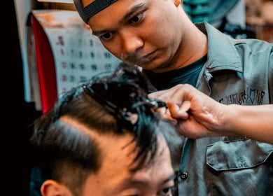 Stylist expertly cutting hair at Big Bad Wolf Barbershop, Singapore, Singapore, SG.