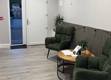 Уютный холл Unveil Beauty в Derrybeg, County Donegal, IE с зелеными креслами и журнальным столиком.