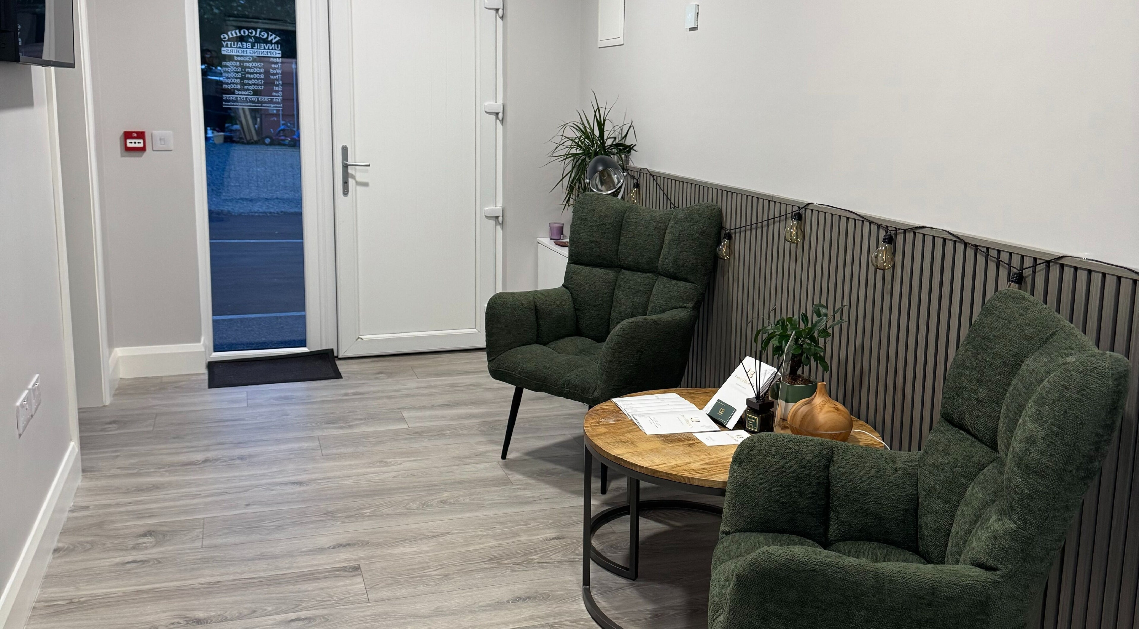 Уютный холл Unveil Beauty в Derrybeg, County Donegal, IE с зелеными креслами и журнальным столиком.