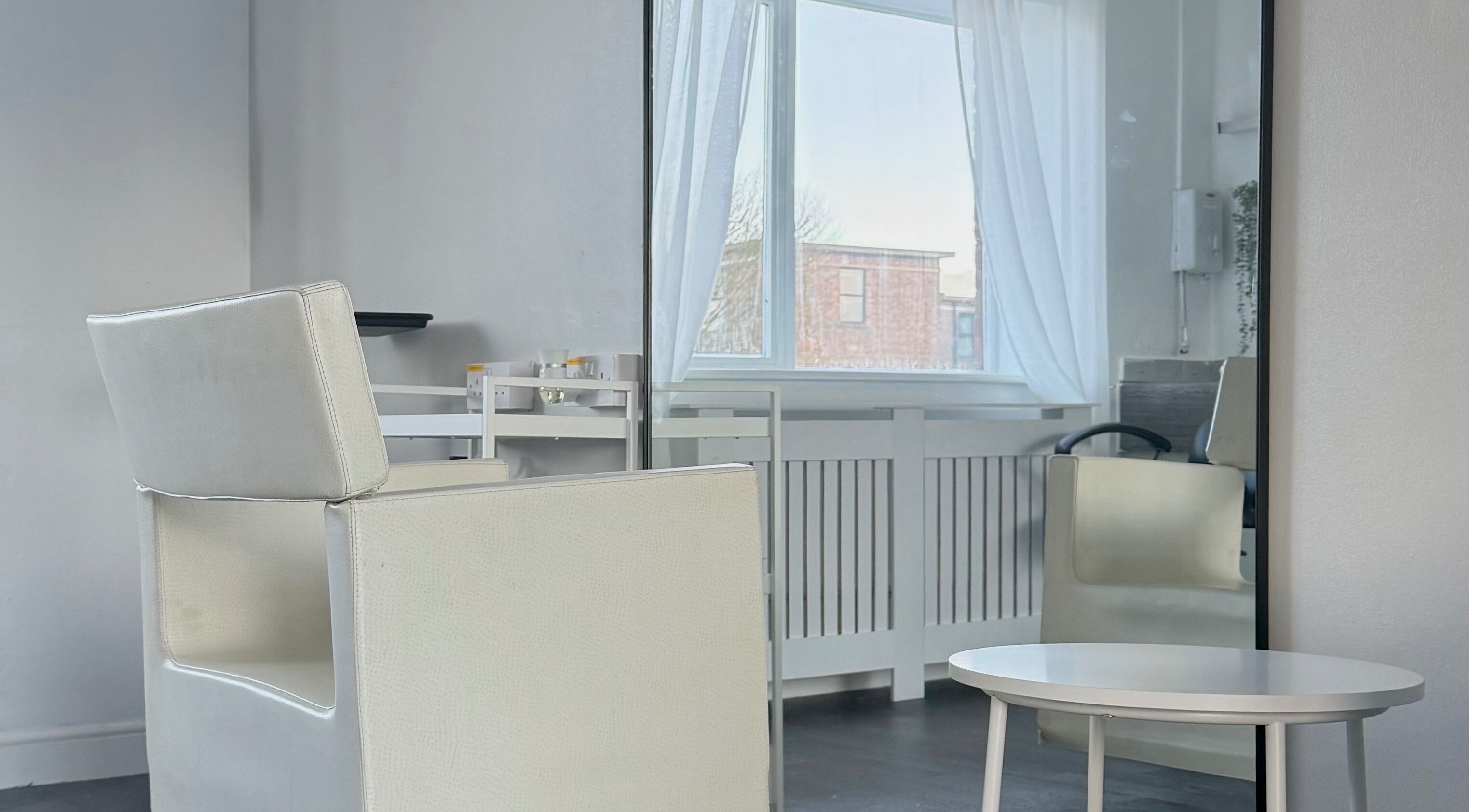 Elegant interior of Gemini Studio in Northallerton, England, GB with chic chair and mirror by the window.