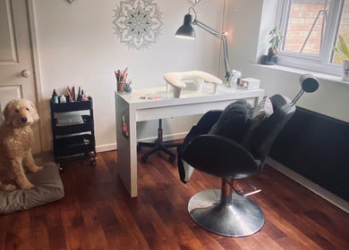 Nikki Halcoop Beauty salon in Donnington, England with a stylish desk, chair, and a friendly dog beside it.