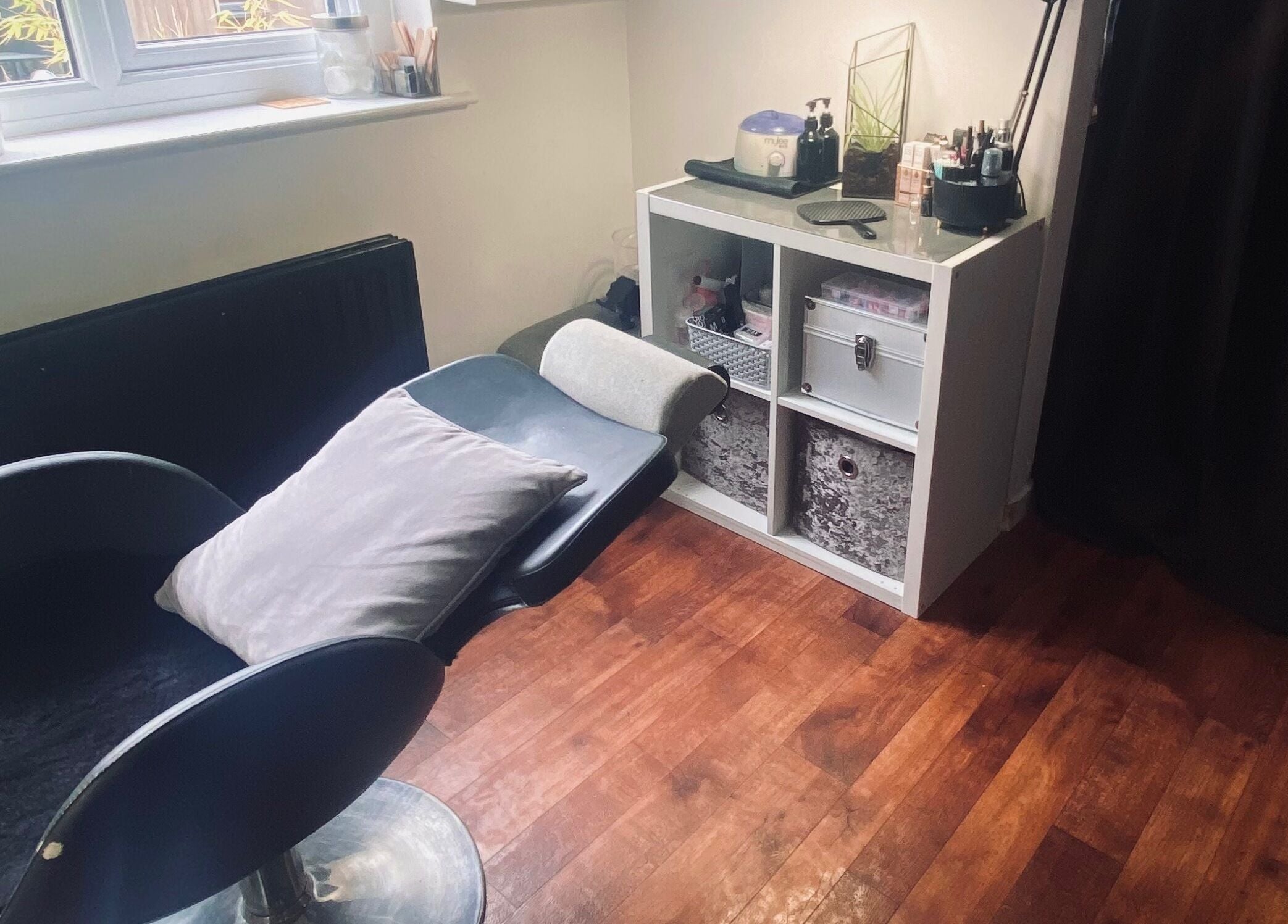Nikki Halcoop Beauty venue in Donnington, England, GB features a relaxing chair and organized shelves.
