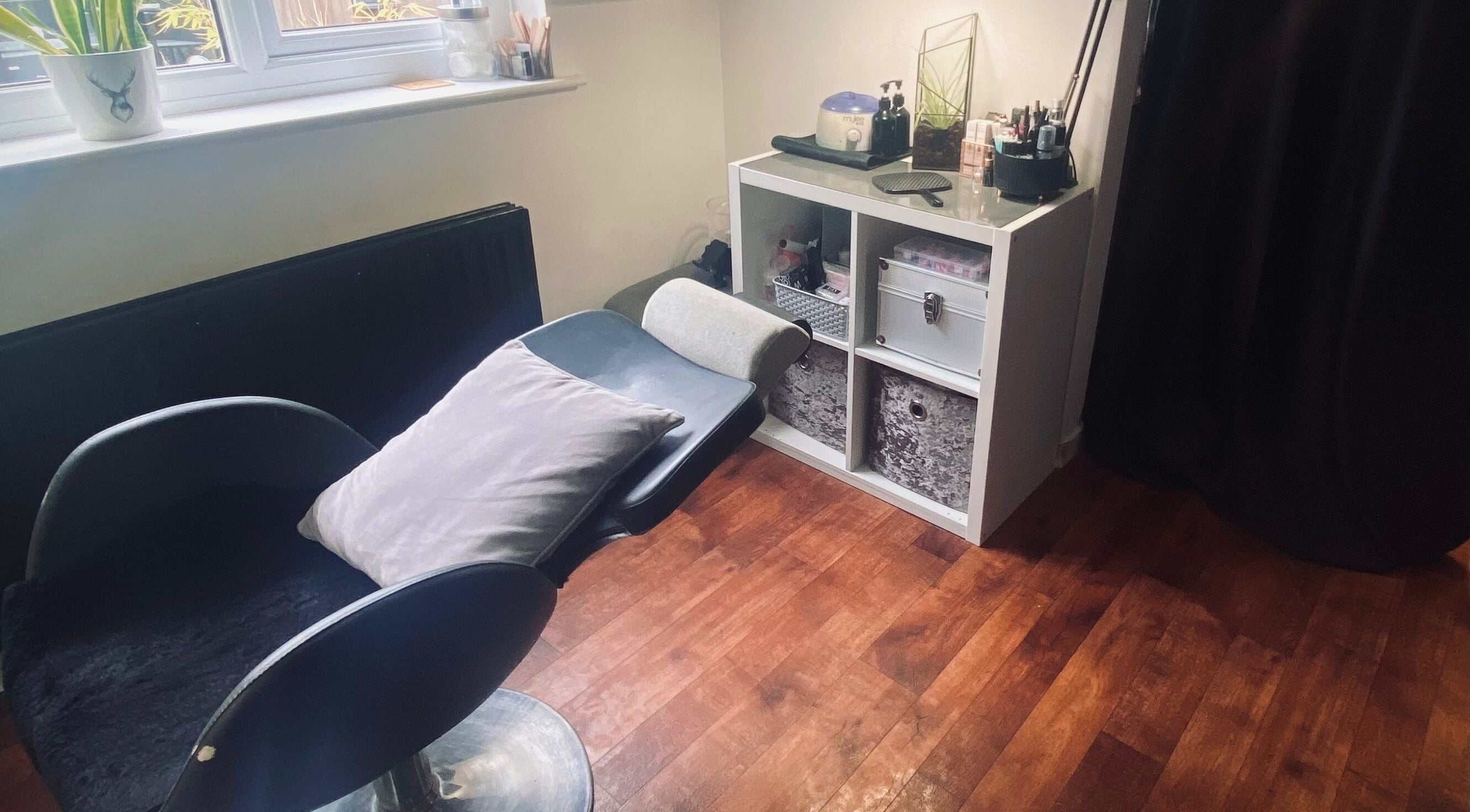 Nikki Halcoop Beauty venue in Donnington, England, GB features a relaxing chair and organized shelves.