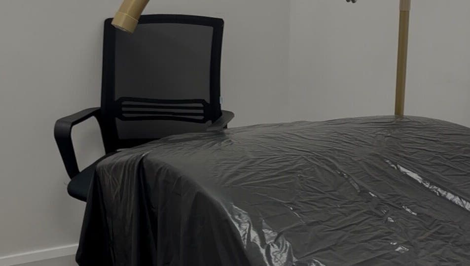 Treatment room at Obsidian Lounge, Dublin, County Dublin, IE with chair and covered massage bed.