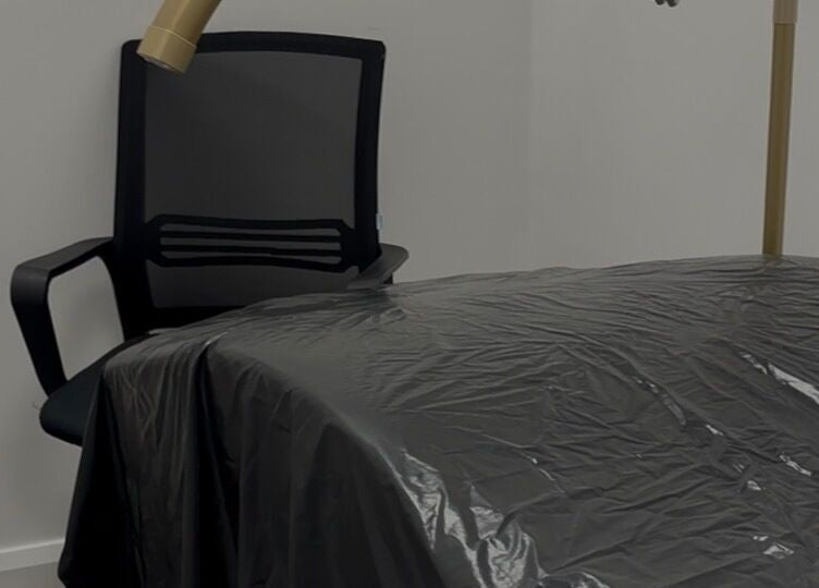 Treatment room at Obsidian Lounge, Dublin, County Dublin, IE with chair and covered massage bed.