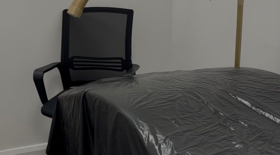 Treatment room at Obsidian Lounge, Dublin, County Dublin, IE with chair and covered massage bed.