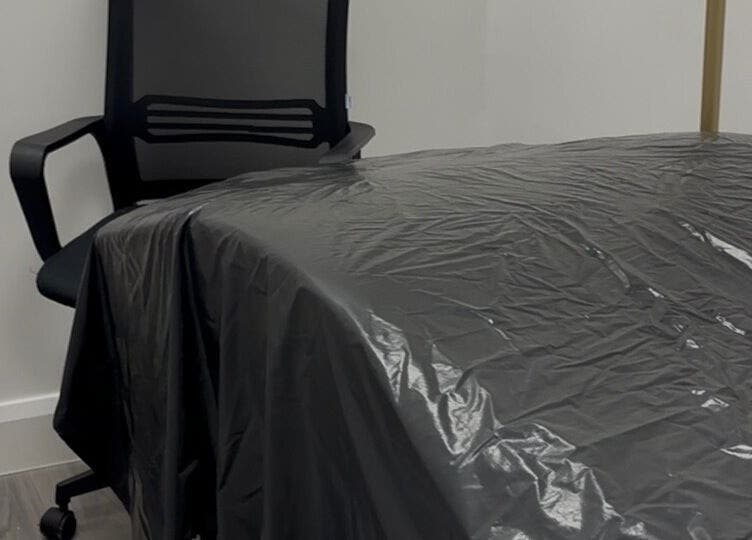 Modern treatment room at Obsidian Lounge, Dublin, County Dublin, IE with black chair and covered table.