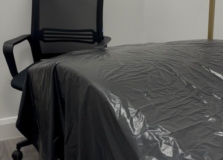 Modern treatment room at Obsidian Lounge, Dublin, County Dublin, IE with black chair and covered table.