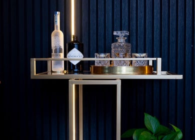 Stylish bar cart at Omen Collective, Fortitude Valley, Queensland, AU with bottles and glassware.