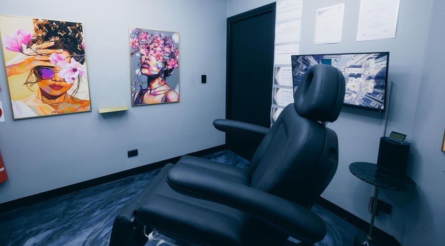 Omen Collective treatment room in Fortitude Valley, Queensland, AU with vibrant wall art and modern chair.