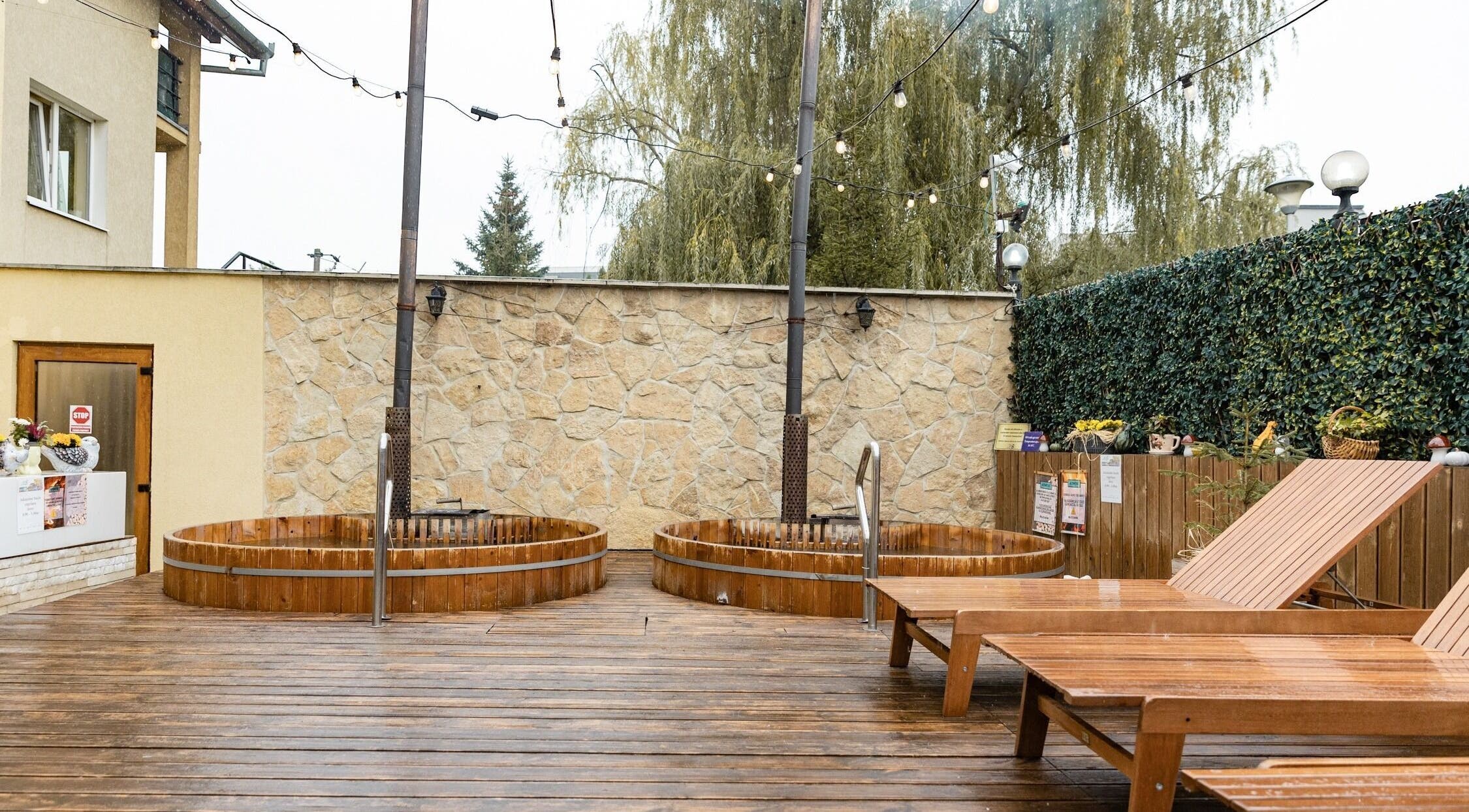 Zona relaxare cu jacuzzi la Salty Spa, Cluj-Napoca, RO, atmosferă exterioară rustică și șezlonguri confortabile.
