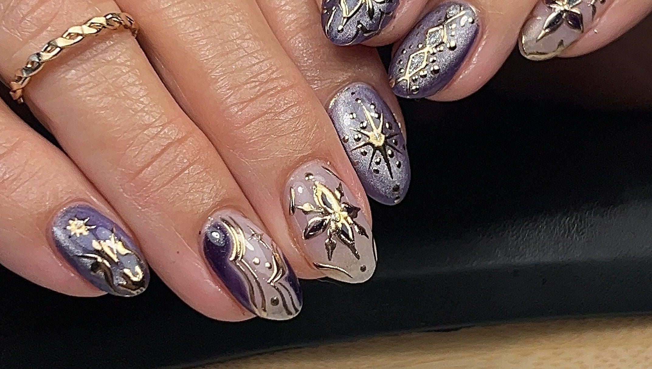 Elegant celestial-themed nails at Cured by Margaret, Guelph, Ontario, CA with intricate gold and purple designs.