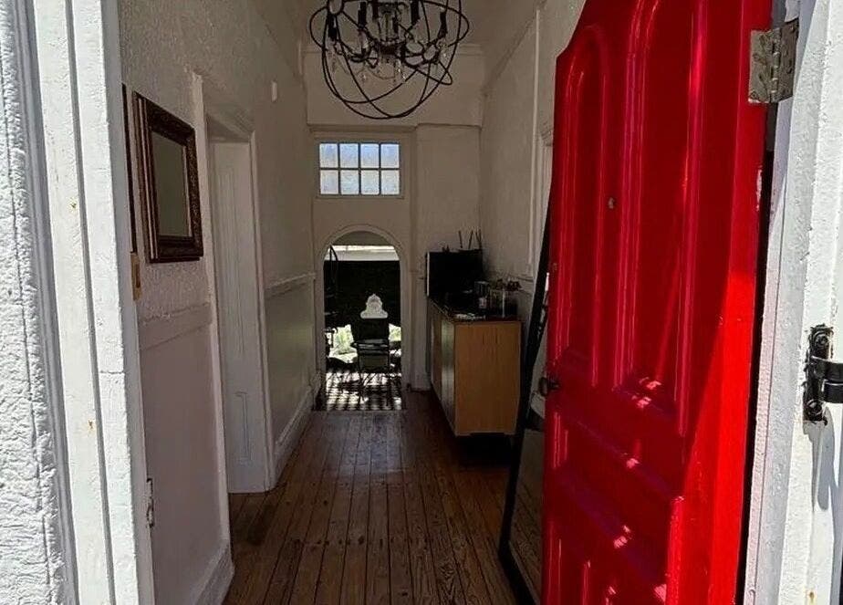 Charming entrance with red door at BrowsbyFadia, Cape Town, Western Cape, ZA, showcasing elegance inside.