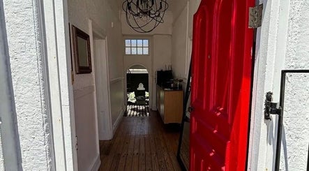Charming entrance with red door at BrowsbyFadia, Cape Town, Western Cape, ZA, showcasing elegance inside.