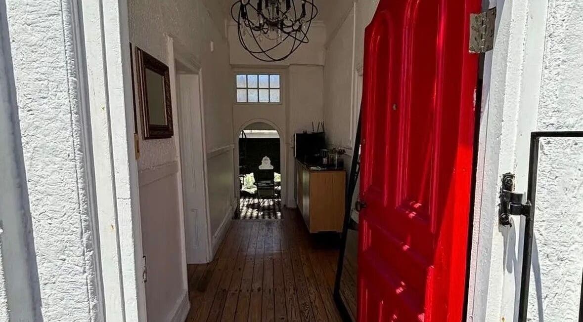 Charming entrance with red door at BrowsbyFadia, Cape Town, Western Cape, ZA, showcasing elegance inside.