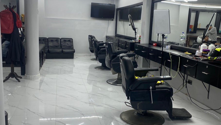 Interior moderno de Perú 51 Barbershop Callao, Callao, PE, con sillas de barbero elegantes y espejo amplio.