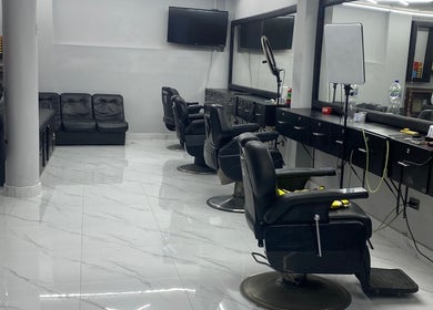 Interior moderno de Perú 51 Barbershop Callao, Callao, PE, con sillas de barbero elegantes y espejo amplio.