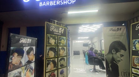 Entrada iluminada de Perú 51 Barbershop Callao, mostrando cortes de tendencia en Callao, Callao, PE.