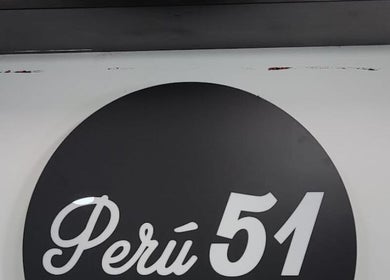 Logo redondo de Perú 51 Barbershop Callao, ubicado en Callao, Callao, PE, sobre pared blanca y gris.