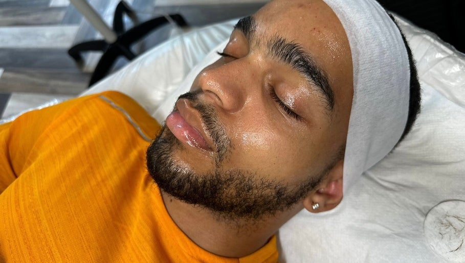 Man enjoying a facial treatment at Muniira's Clinic, London, England, GB, with a serene expression.