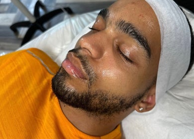 Man enjoying a facial treatment at Muniira's Clinic, London, England, GB, with a serene expression.