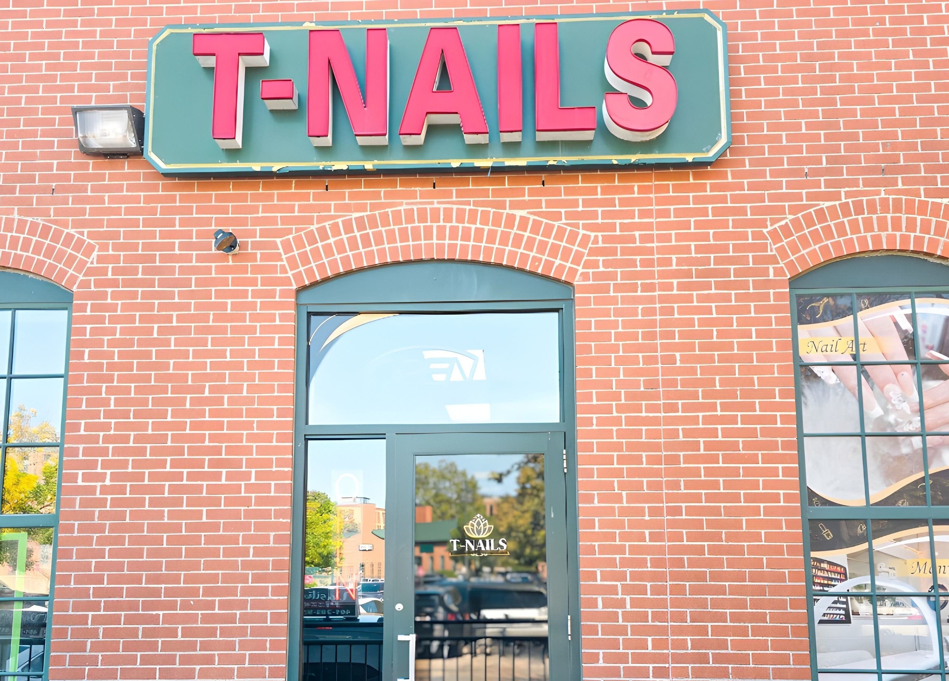 Entrance of T-Nails Glam Studio in Providence, Rhode Island, US with large signage on a brick wall.