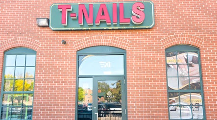 Entrance of T-Nails Glam Studio in Providence, Rhode Island, US with large signage on a brick wall.