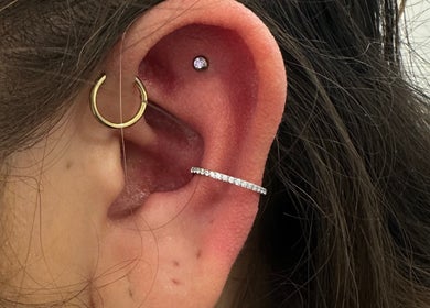 Stylish ear piercing with gold and silver hoops at ILW Body Piercing, Glenfield, England, GB.