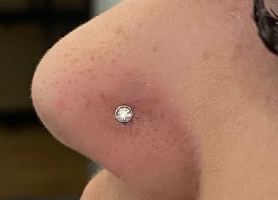 Close-up of nostril piercing with gem at ILW Body Piercing in Glenfield, England, GB.