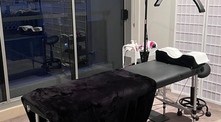 A relaxing treatment room at The Lab Studio in Waterloo, NSW, AU, showcasing a massage table beside a large window.