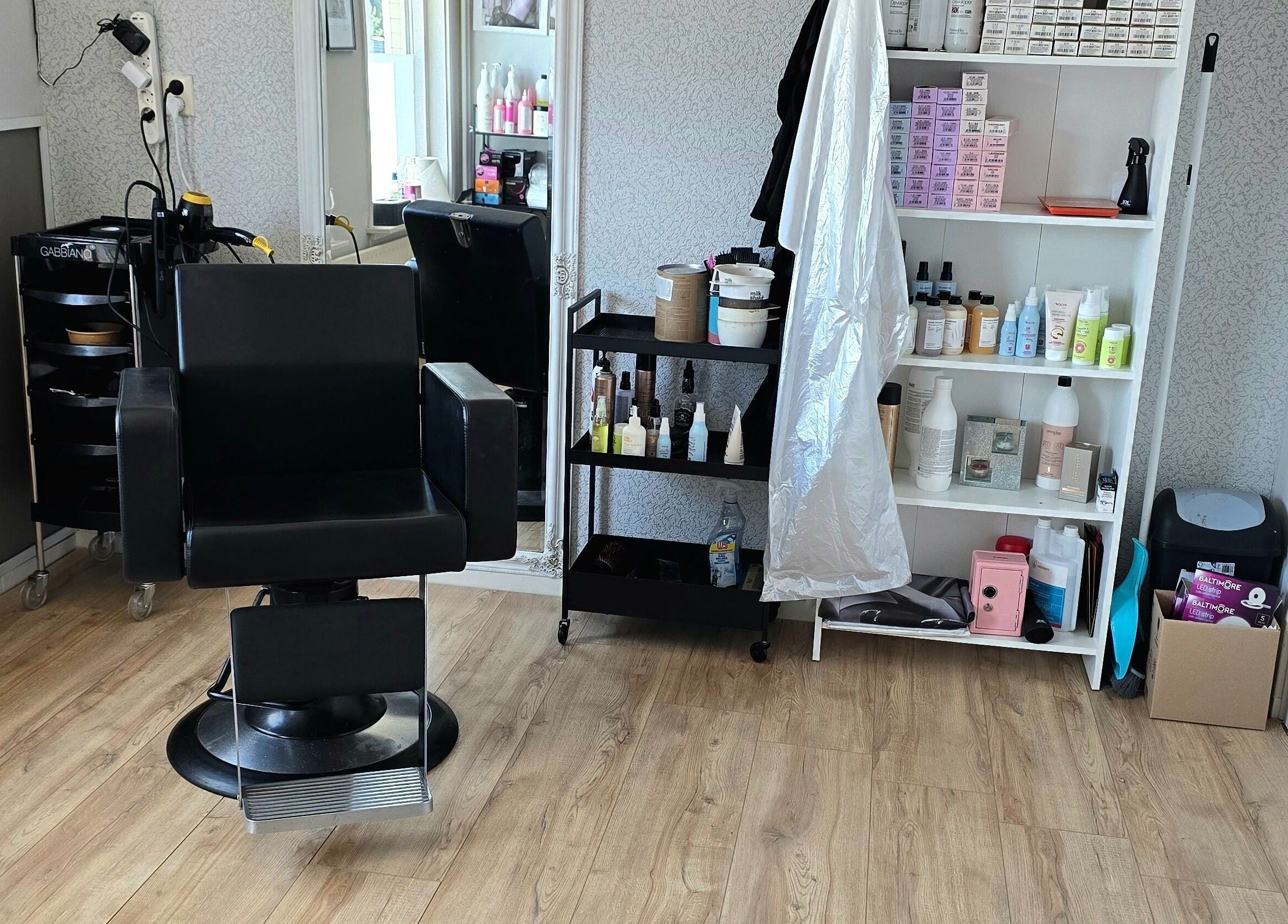 Stylowy fotel fryzjerski w HairShine by P.A Rozycka, Obdam, Noord-holland, NL, otoczony produktami do pielęgnacji.