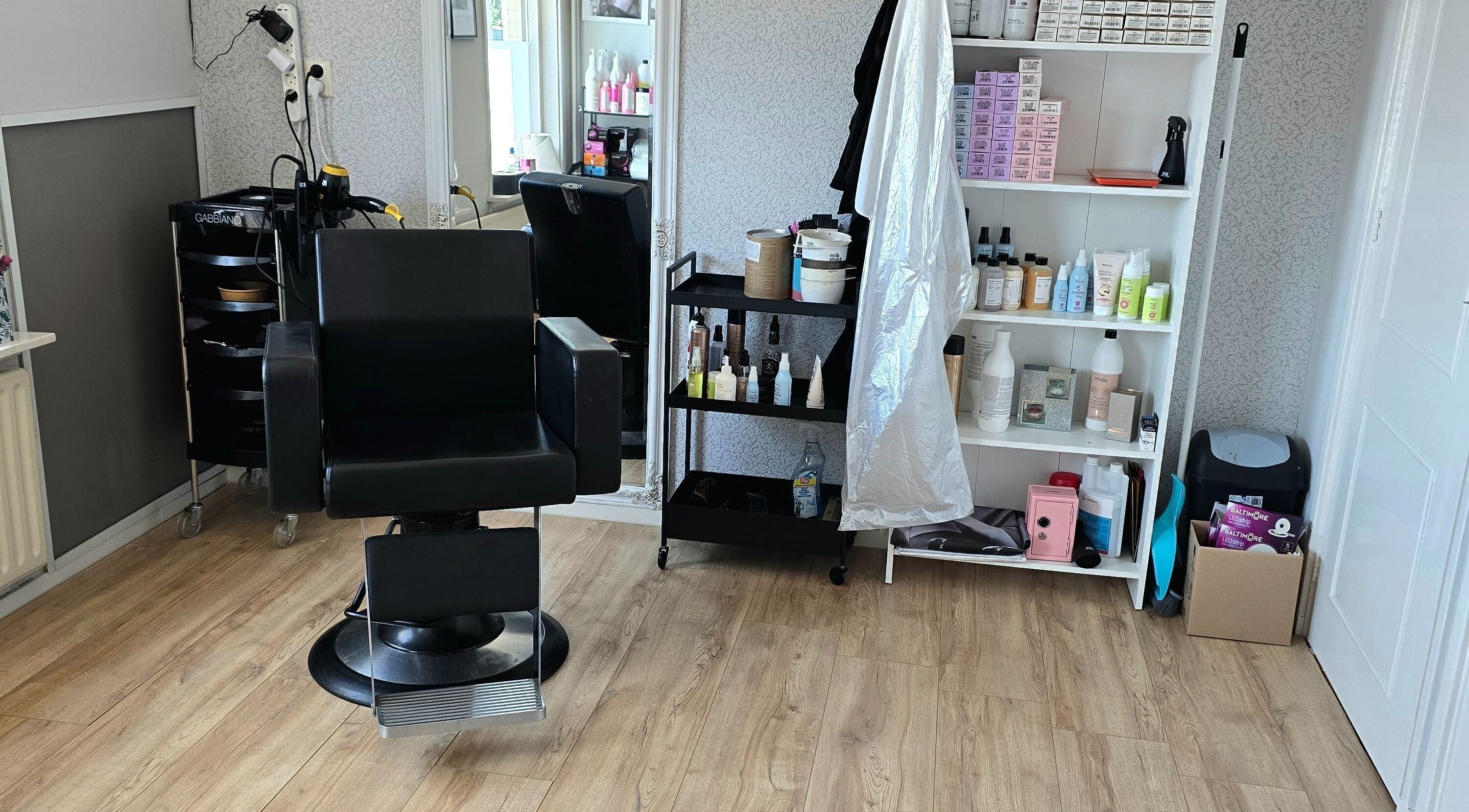 Stylowy fotel fryzjerski w HairShine by P.A Rozycka, Obdam, Noord-holland, NL, otoczony produktami do pielęgnacji.