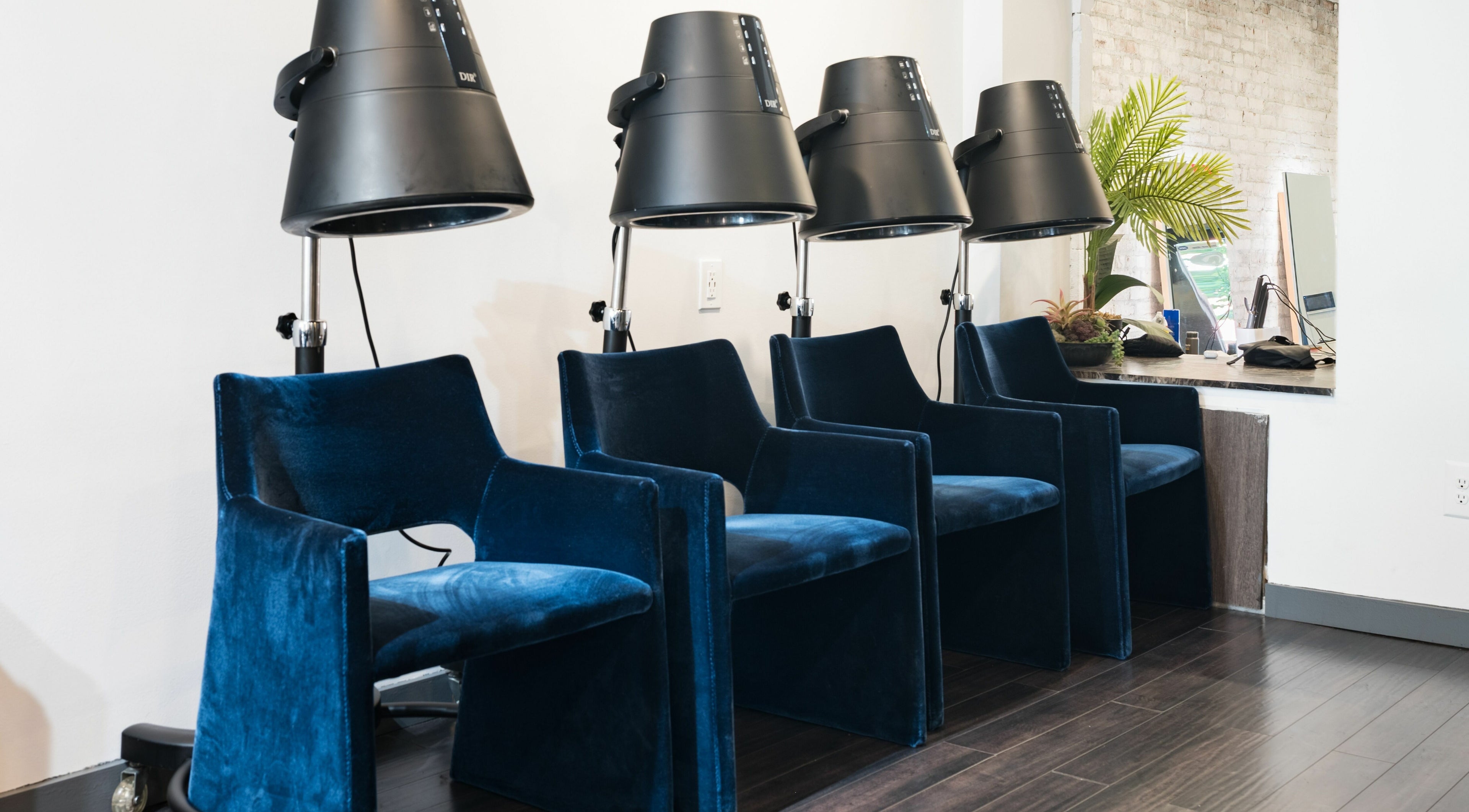 Plush blue chairs under modern dryers at H2 Salon Brooklyn, New York, New York, US creating a sleek atmosphere.