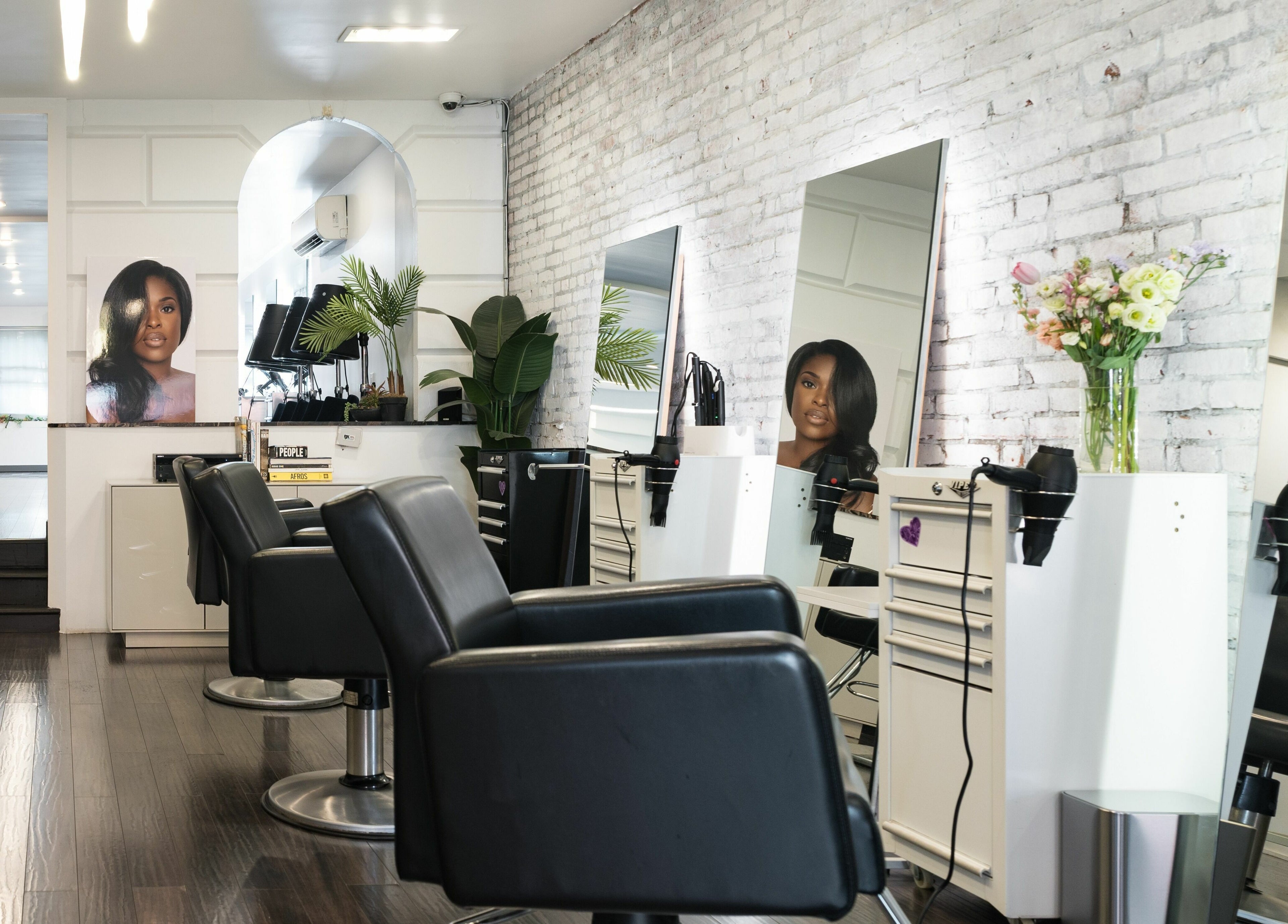H2 Salon Brooklyn interior with sleek black chairs and mirrors in New York, New York, US.