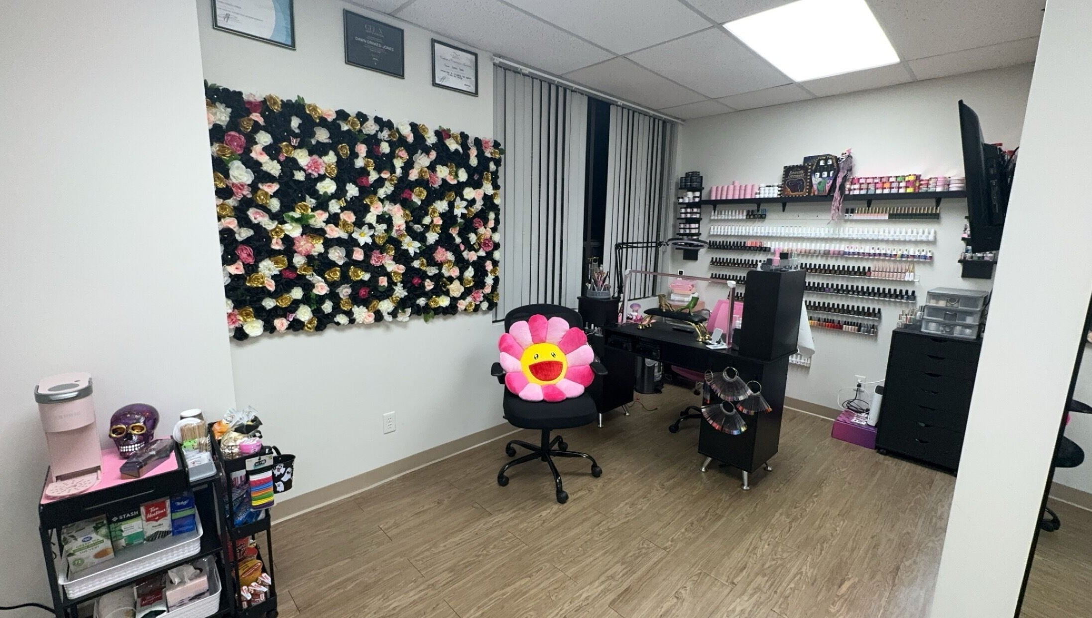 Beauty Girl Studios, Toronto, Ontario, CA. Cozy salon room with floral wall and nail supplies.